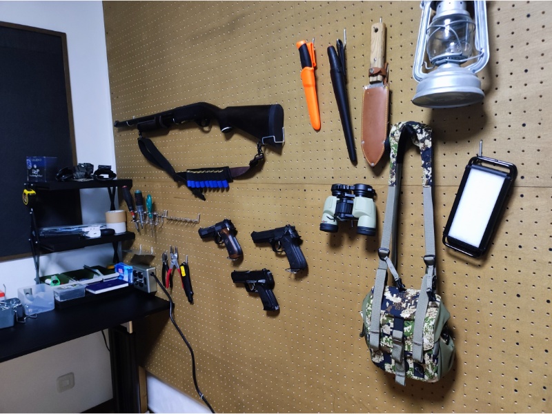 壁に飾られた工具やおもちゃの鉄砲などの写真